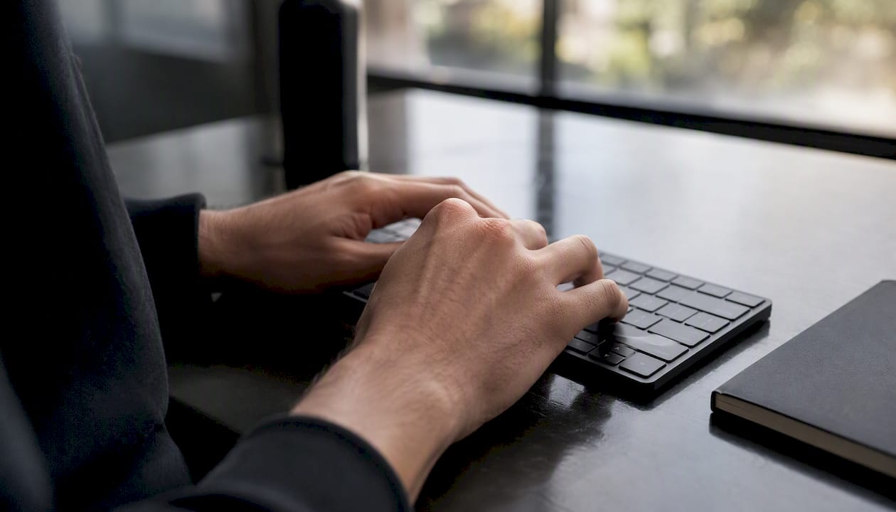 Hands typing trademark symbol on keyboard