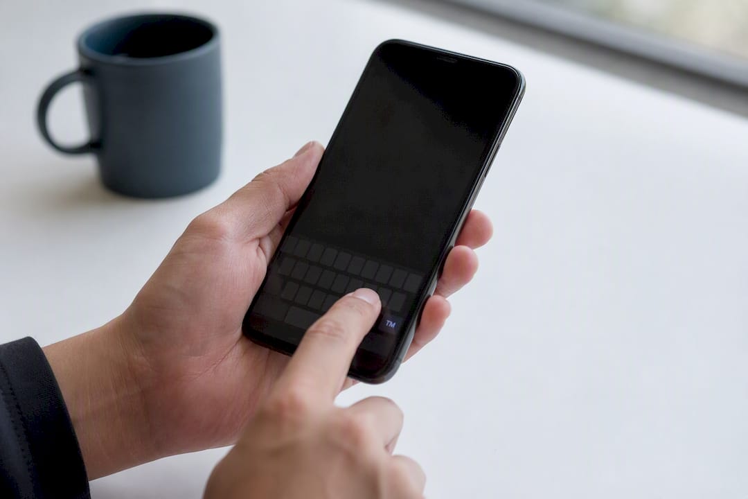 Hand long-pressing trademark symbol on smartphone