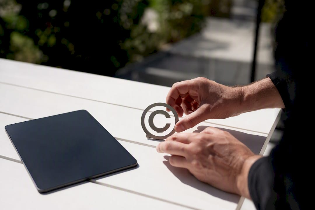 Hands placing copyright symbol plaque by laptop