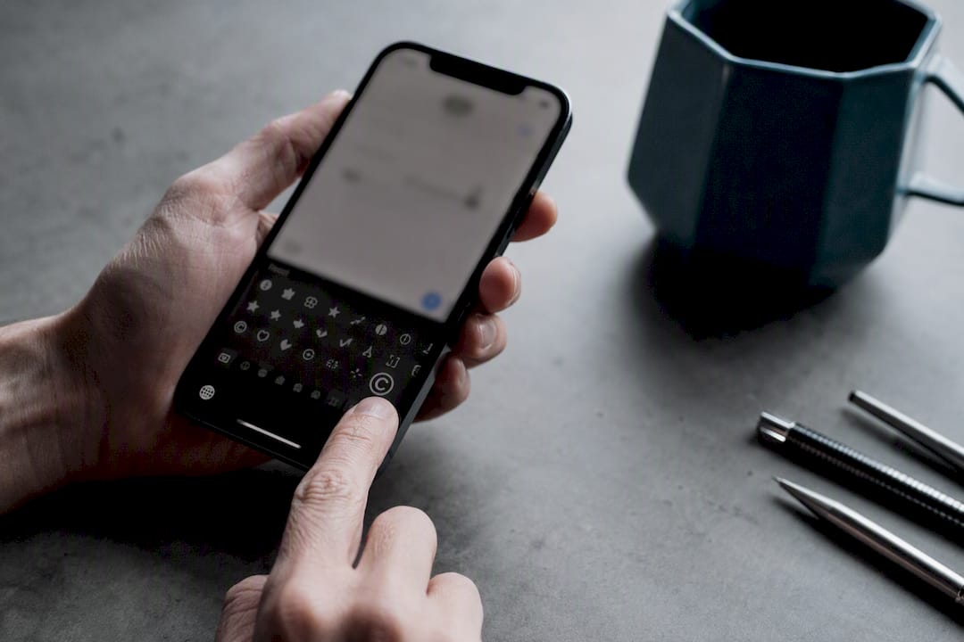 Finger tapping copyright symbol on iPhone emoji keyboard