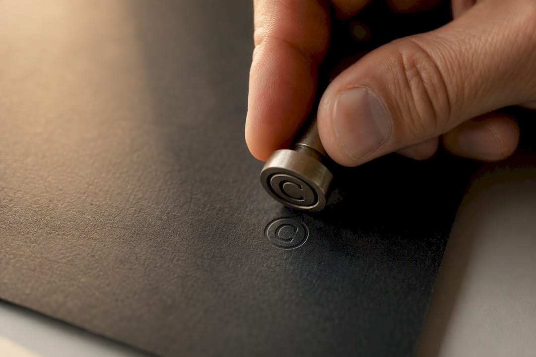 Hand stamping copyright symbol on leather